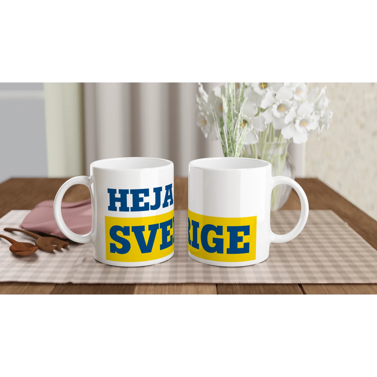 Två helvita kaffemuggar med gult och blått tryck 'HEJA SVERIGE'. En klassisk souvenir från kollektionen för svenska supportrar.