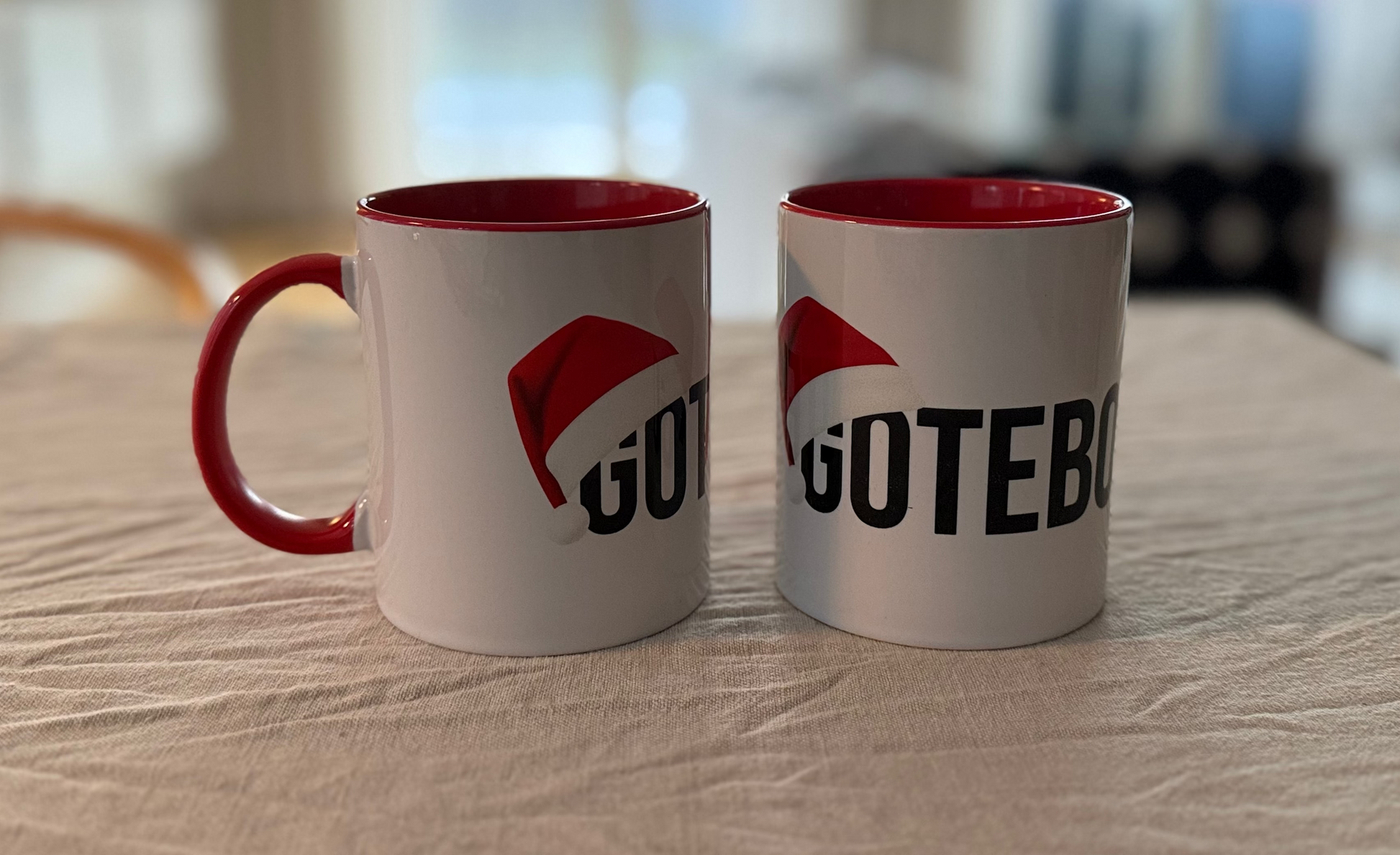 Vit kaffekopp med röda inslag på örat och inuti. Göteborg står skrivet över muggen och en tomteluva täcker början av ordet.