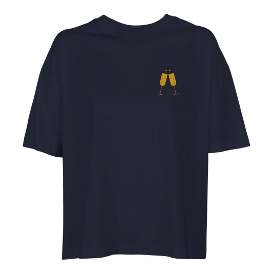 Marinblå oversized dam-t-shirt i ekologisk bomull med guldtryck av champagneglas på bröstet.