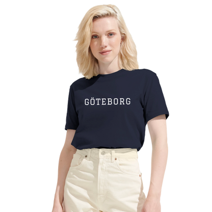 Kvinna i marinblå Göteborg t-shirt med college-motiv. Visar den moderna passformen på denna ekologiska dam-t-shirt.