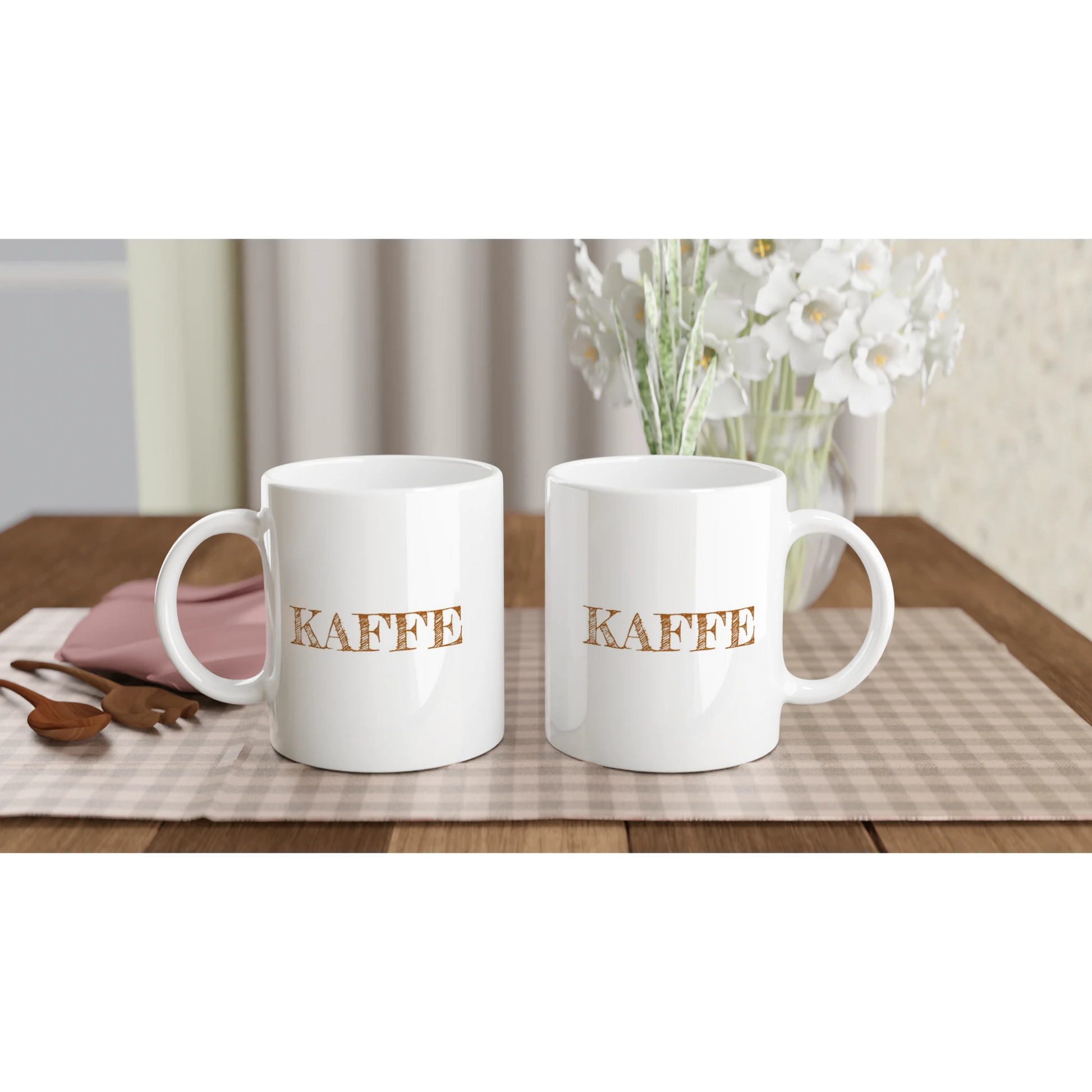Två helvita kaffemuggar med texten KAFFE, visade på ett bord för att demonstrera trycket på båda sidor. Perfekt present till fikaälskaren.