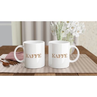 Två helvita kaffemuggar med texten KAFFE, visade på ett bord för att demonstrera trycket på båda sidor. Perfekt present till fikaälskaren.