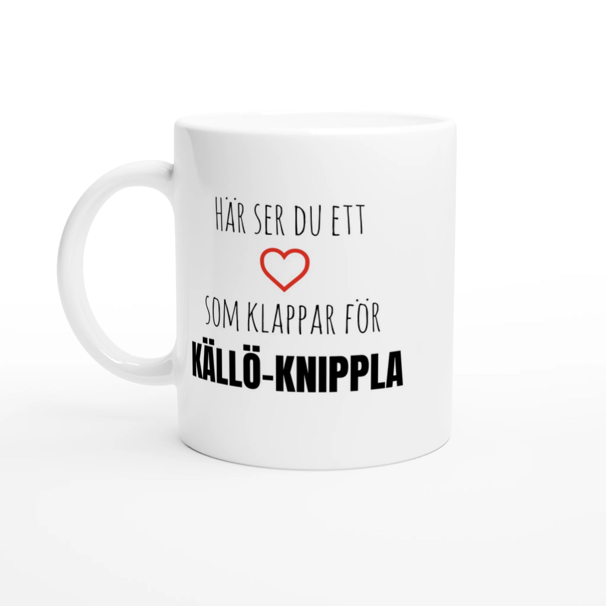 Vit kaffemugg med texten 'Här ser du ett hjärta som klappar för Källö-Knippla' och ett rött hjärta. En stilren mugg för alla med hjärtat i norra skärgården.