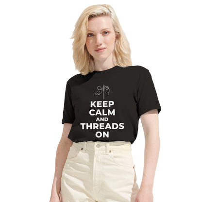Kvinna bär en svart t-shirt med sy-motiv. Visar den moderna och bekväma passformen för denna kreativa dam-t-shirt.