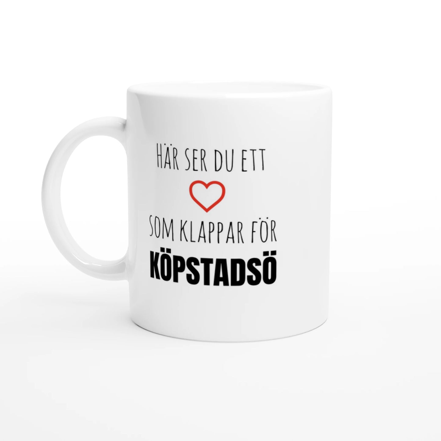 Vit kaffemugg med texten 'Här ser du ett hjärta som klappar för Köpstadsö' och ett rött hjärta. En unik souvenir från Kössö i Göteborgs skärgård.