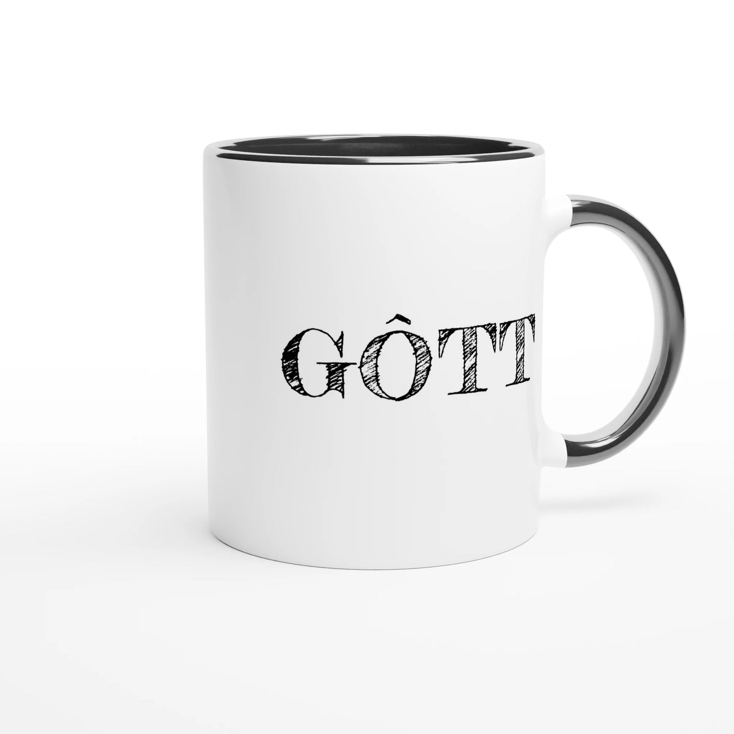 Detaljbild av baksidan av den vita kaffemuggen med svart insida, med trycket GÔTT och örat vänt bortåt för att visa muggens fulla design.