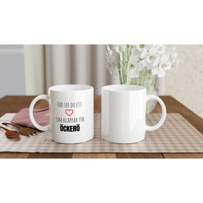Två vita kaffekoppar med Öckerö-motiv på ett dukat bord. Perfekt presenttips till någon med rötter i Göteborgs skärgård.
