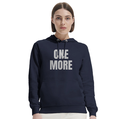 Kvinna bär en marinblå One More hoodie i ekologisk bomull. En bekväm och snygg tröja perfekt för uppvärmning eller vardagsbruk.