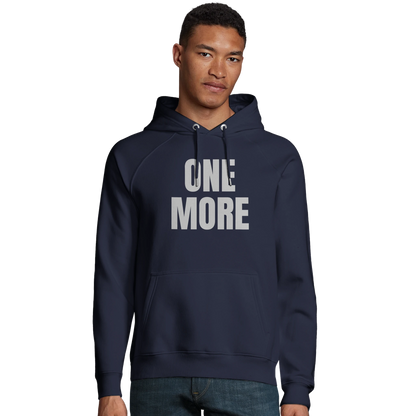 Man i marinblå ekologisk huvtröja från One More. Visar passformen på denna sportiga och hållbara hoodie.