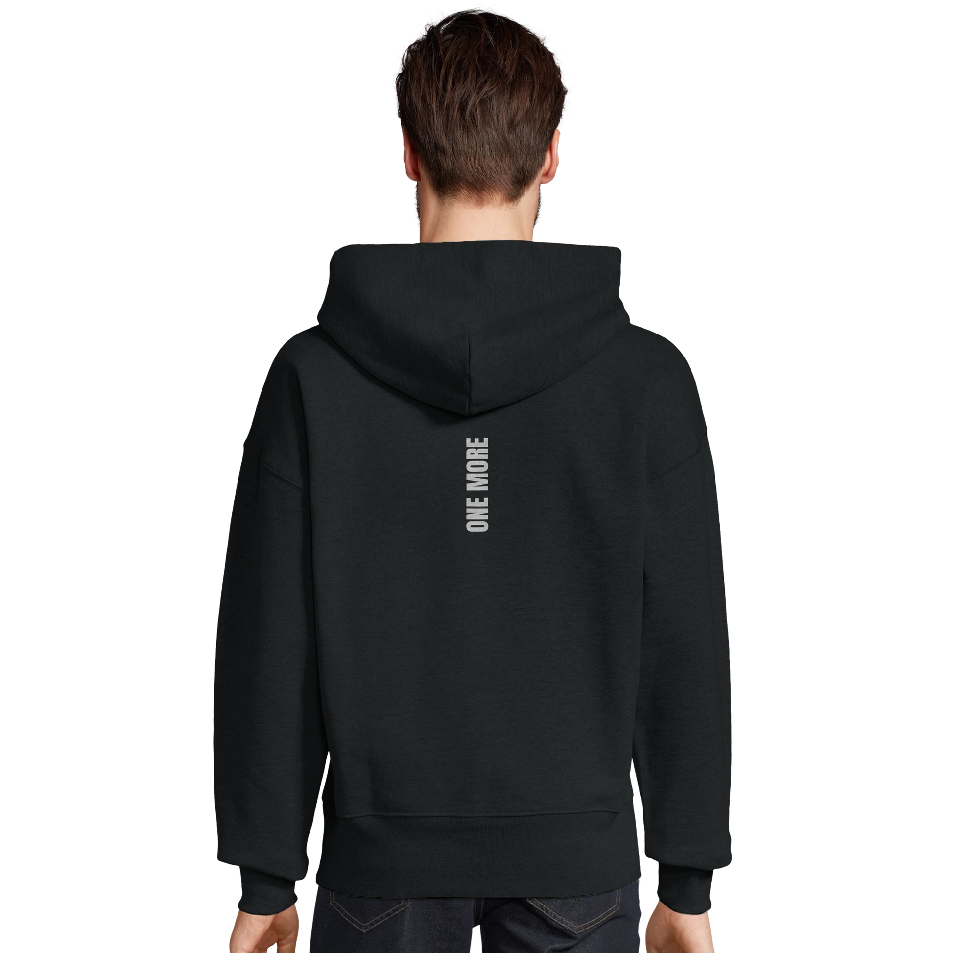 Man sedd bakifrån i en svart oversized hoodie. Visar den atletiska passformen och det vertikala trycket längs ryggen.