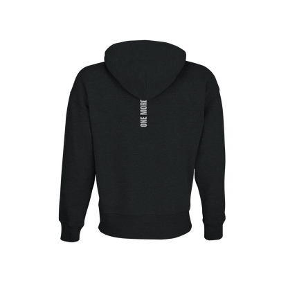 Baksidan av en svart oversized hoodie med vertikalt 'ONE MORE' tryck. En hållbar och varm huvtröja tillverkad av återvunnet material.