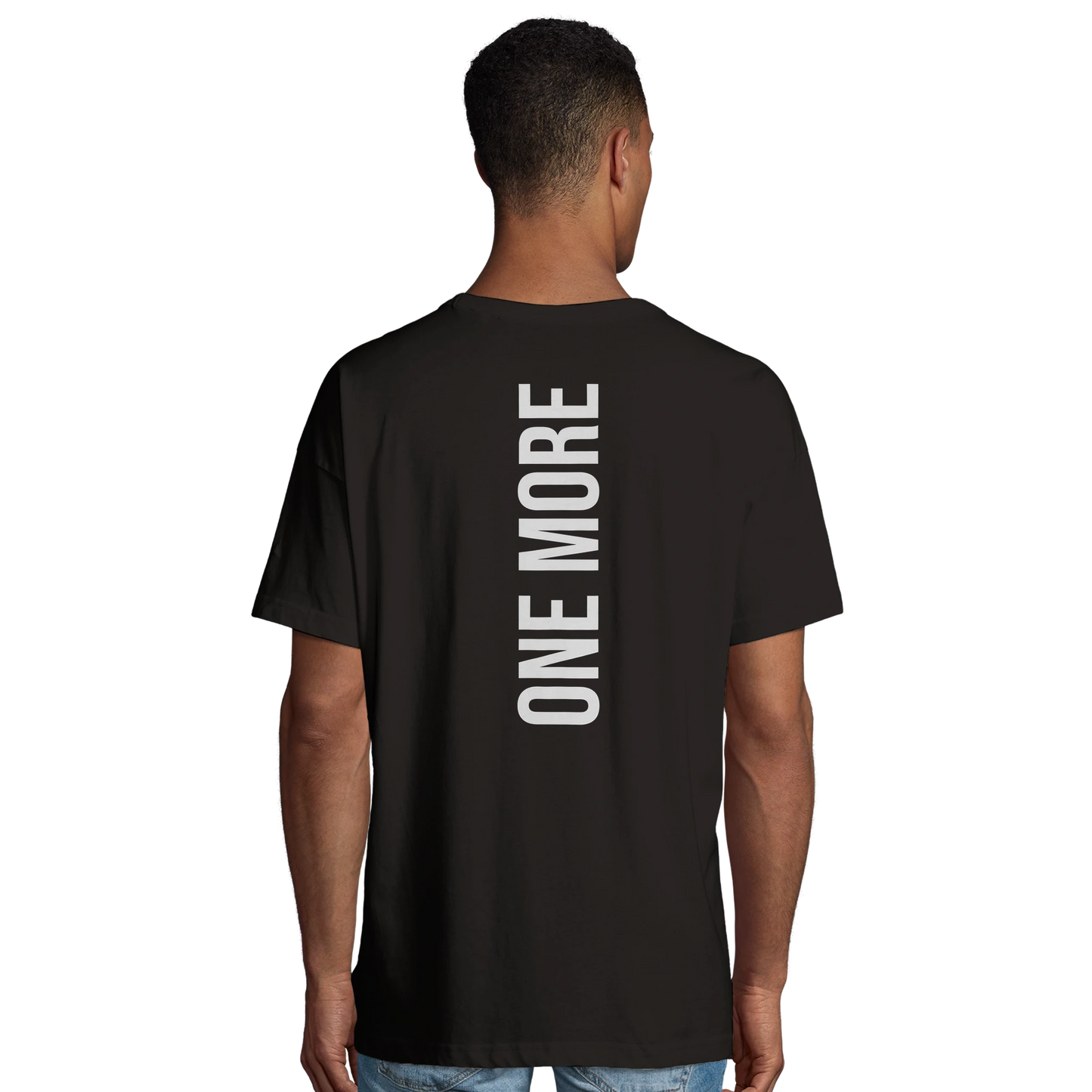 Manlig modell som visar det stora vertikala "ONE MORE"-trycket på ryggen av en svart oversized gym-t-shirt.