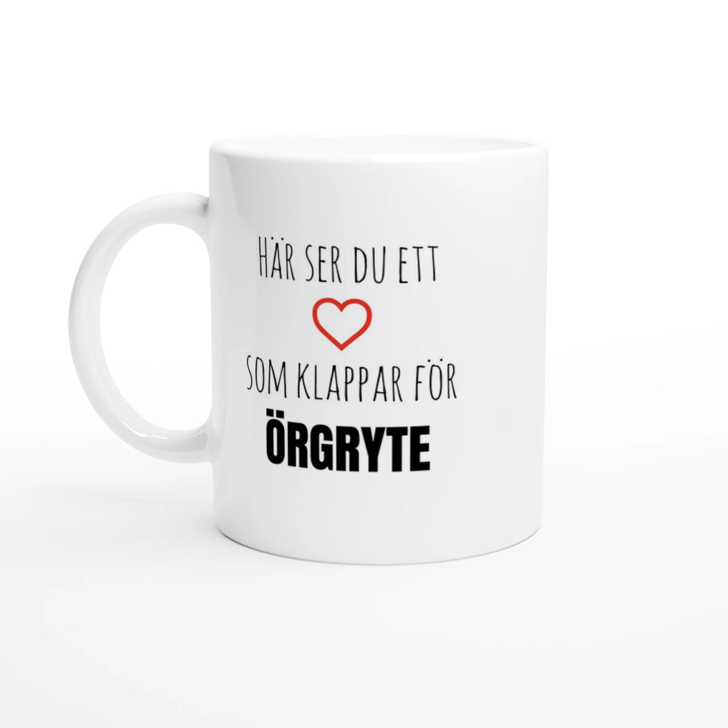 Vit kaffemugg med texten 'Här ser du ett hjärta som klappar för Örgryte' och ett rött hjärta. En elegant kopp för alla med hjärtat i Örgryte.