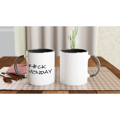 En 'F#CK MONDAY' mugg med svart insida placerad på en duk. Visar muggens storlek och stil i en naturlig miljö för kaffepausen.