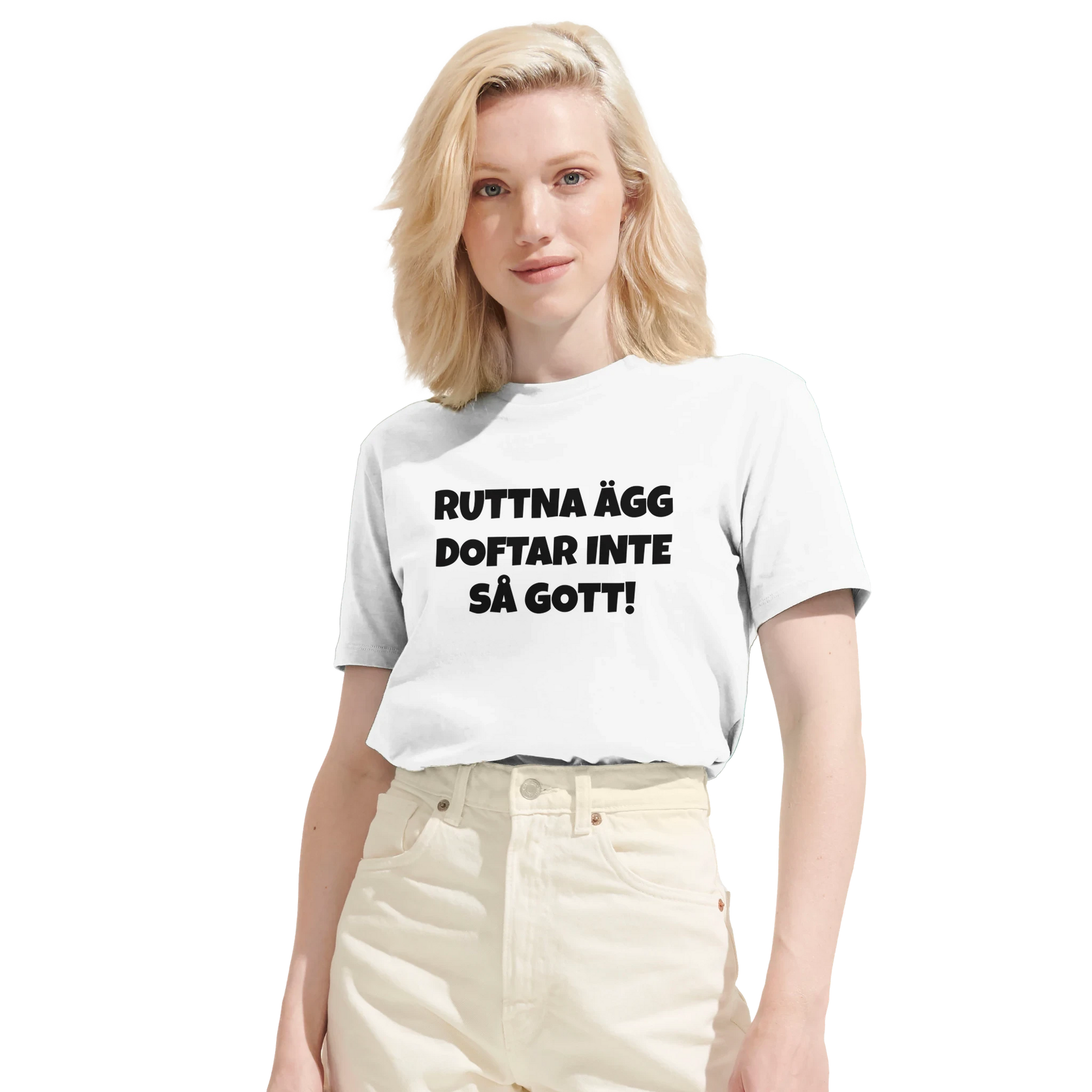 Kvinna bär en vit t-shirt med texten 'Ruttna ägg doftar inte så gott'. Visar den moderna passformen på denna roliga tröja.