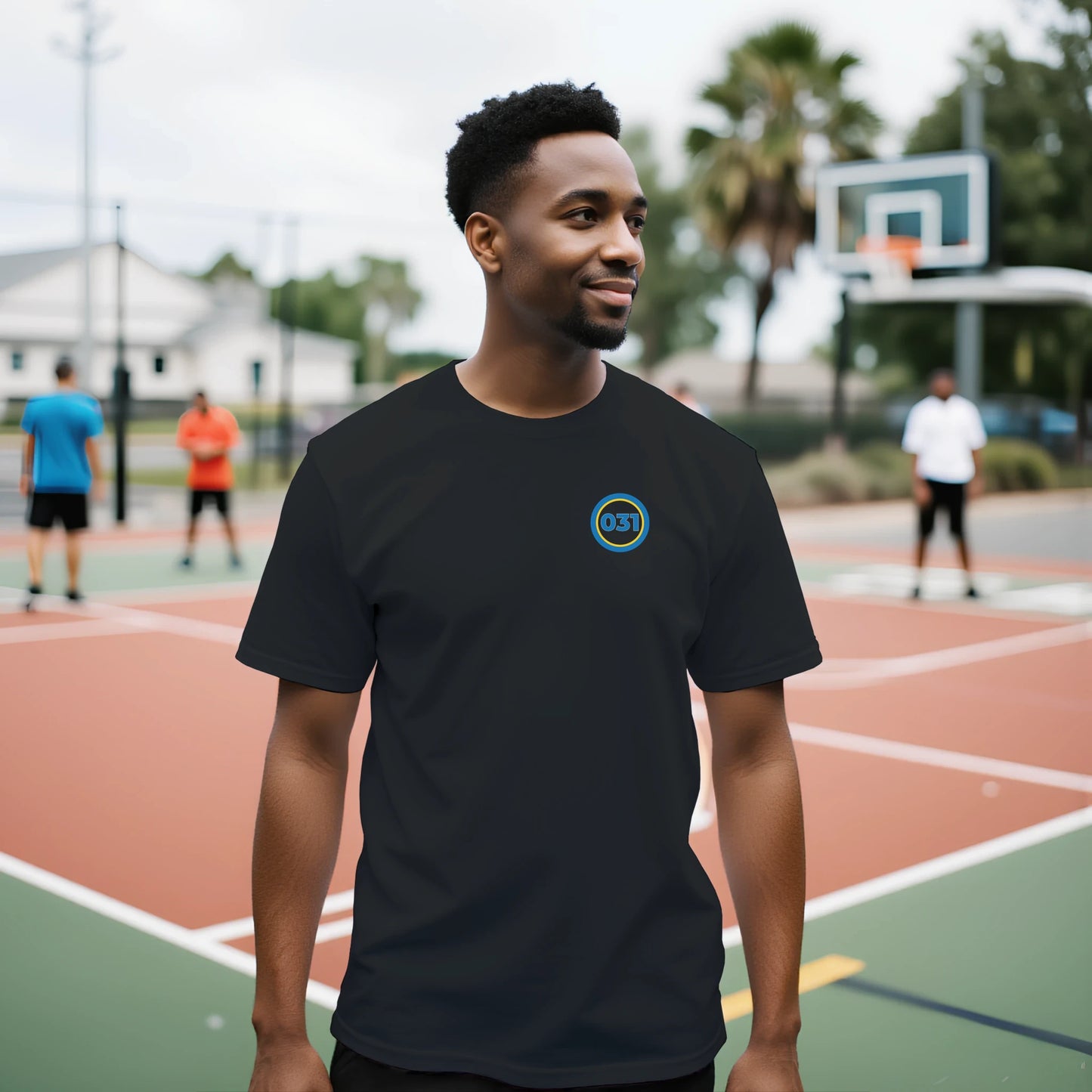 Man ståendes utomhus på basketplan. Iklädd svart t-shirt med 031 över vänstra bröstet.