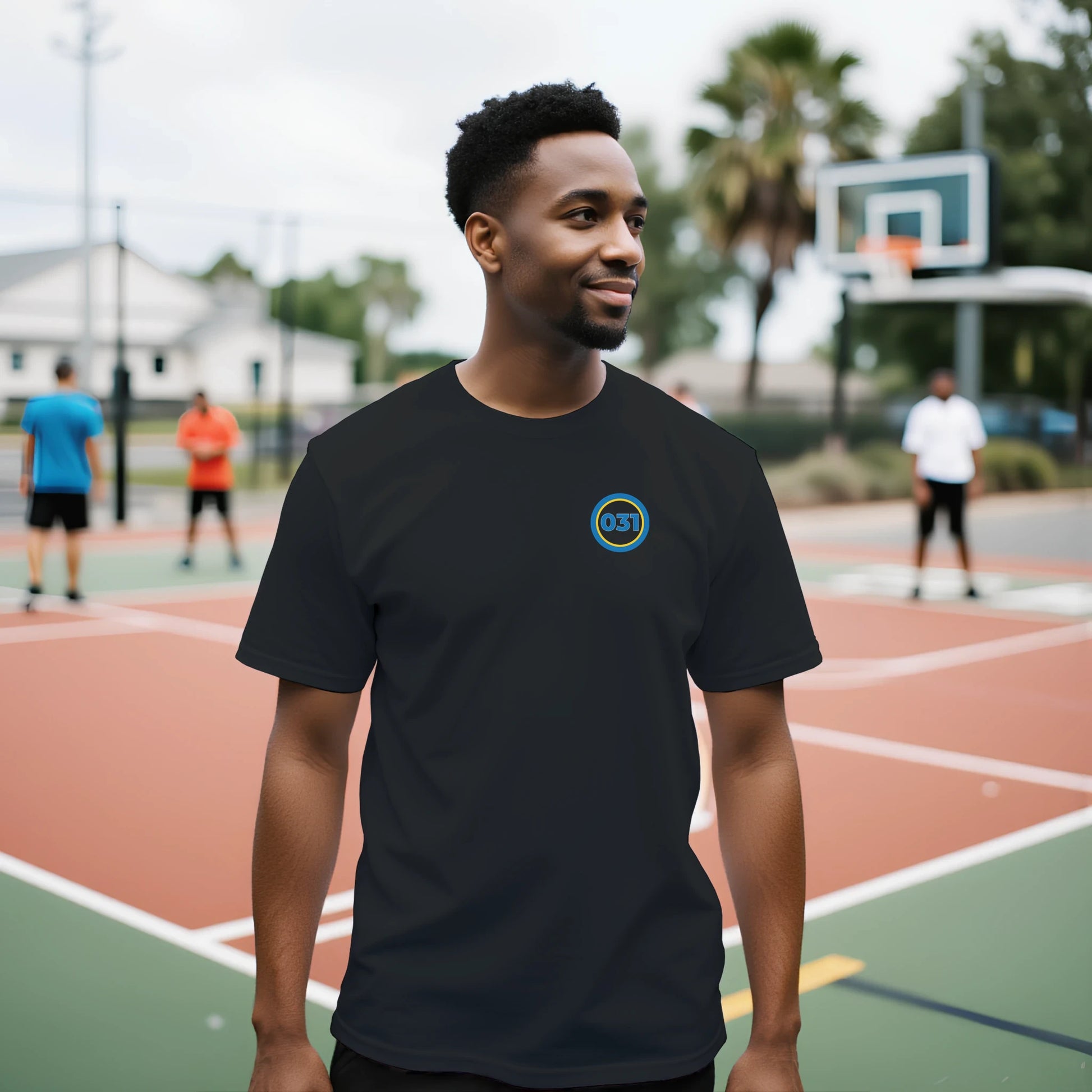 Man ståendes utomhus på basketplan. Iklädd svart t-shirt med 031 över vänstra bröstet.